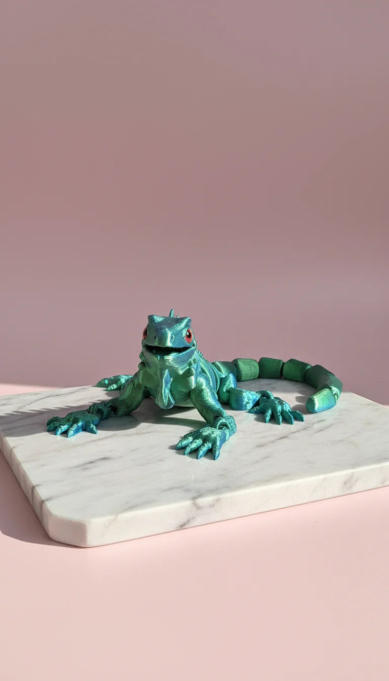 Turquoise lizard figurine on a marble surface with a pink background