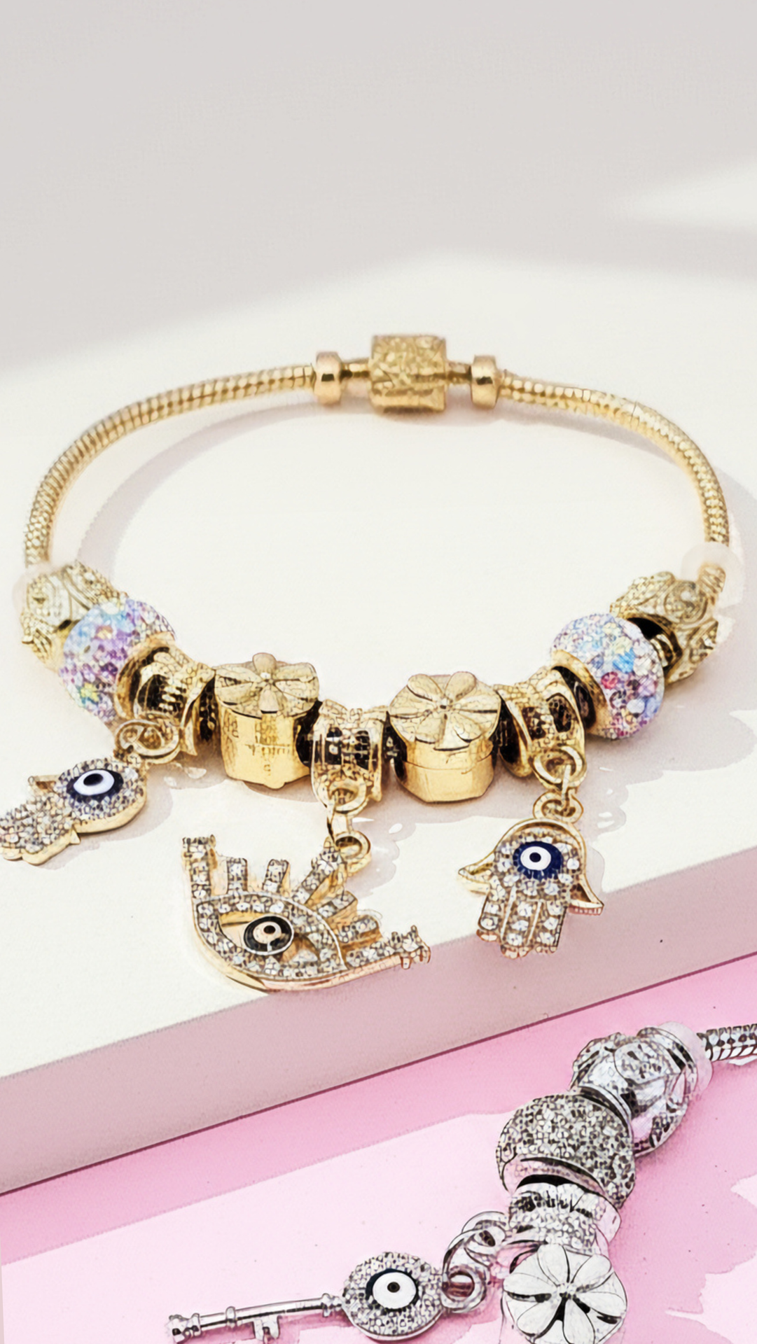 Golden bracelet with charms displayed against a white background