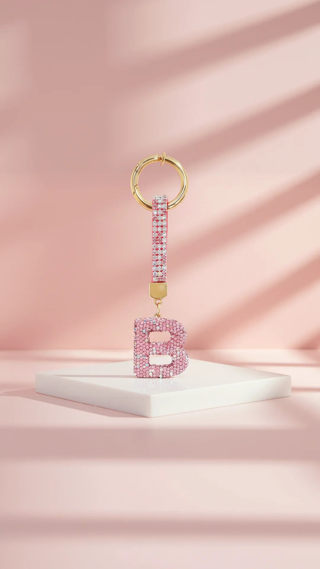 Pink letter 'B' keychain with gold accents on a pink background