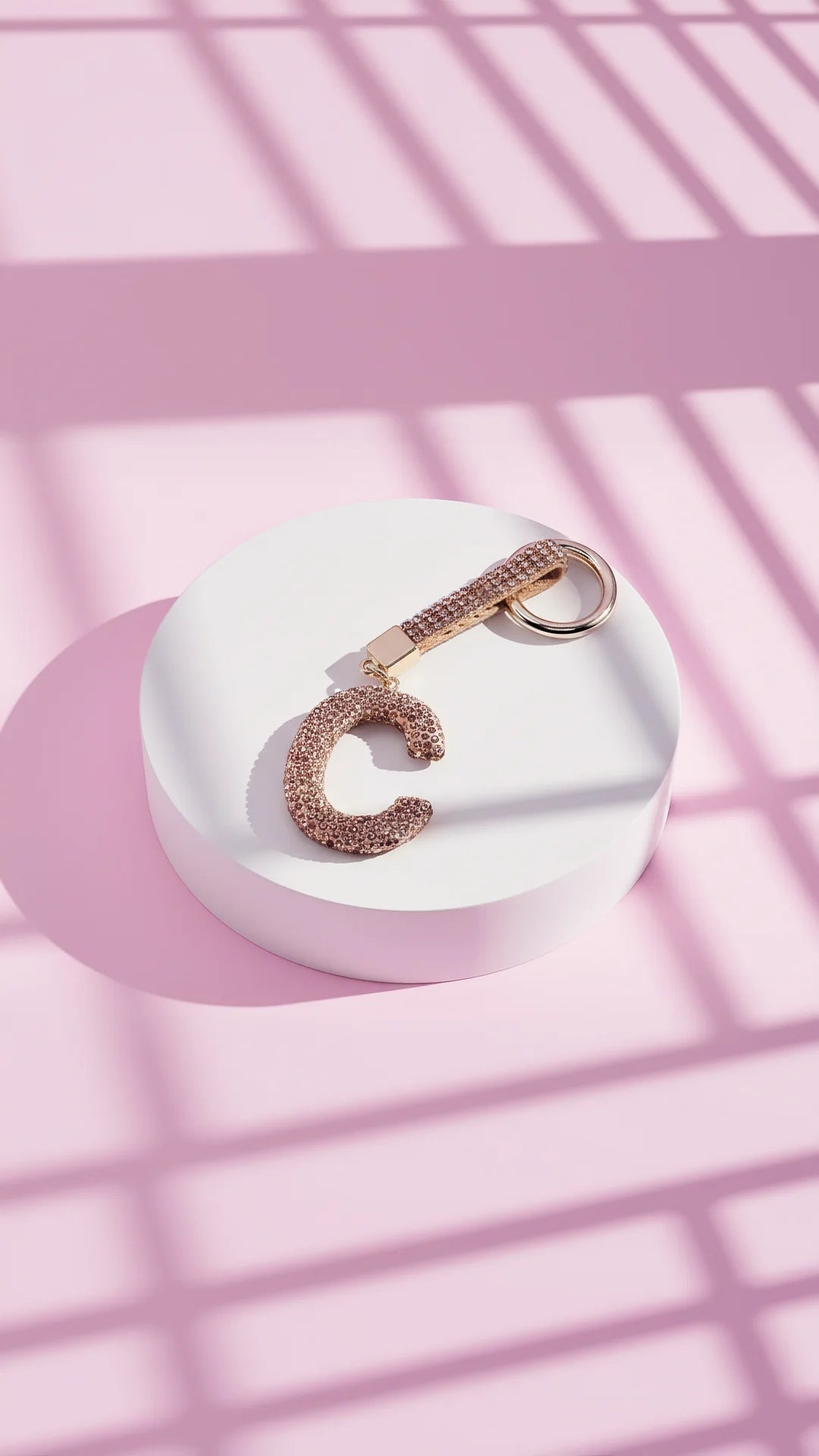 Keychain with letter 'C' on a pink and white striped background