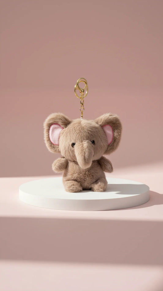 Fluffy brown elephant keychain on a white base with pink background