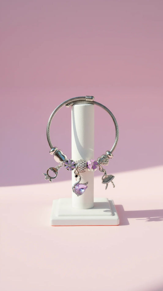 Bracelet with charms on a white stand against a pink background