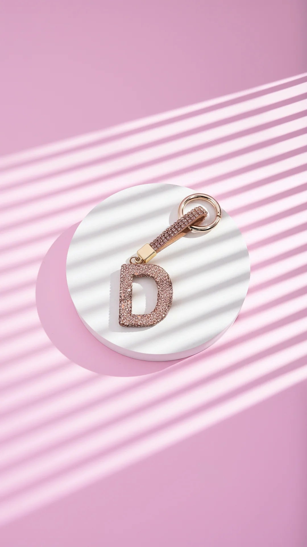 Keychain with 'D' charm on a pink background