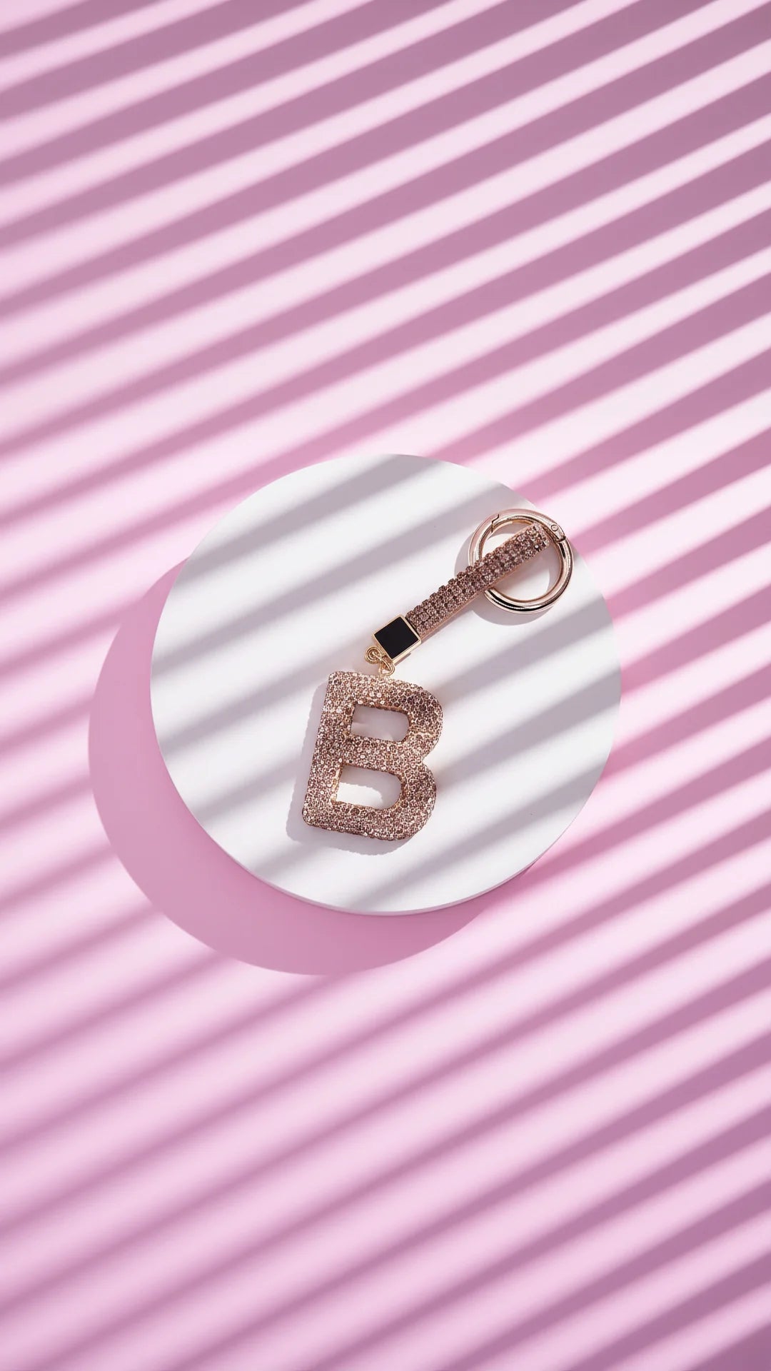 Keychain with letter 'B' on a pink and white striped background