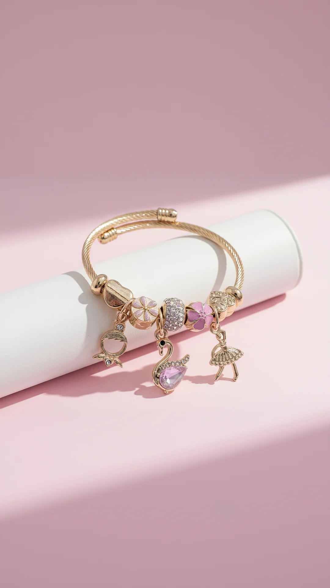 Golden bracelet with charms on a white surface with background