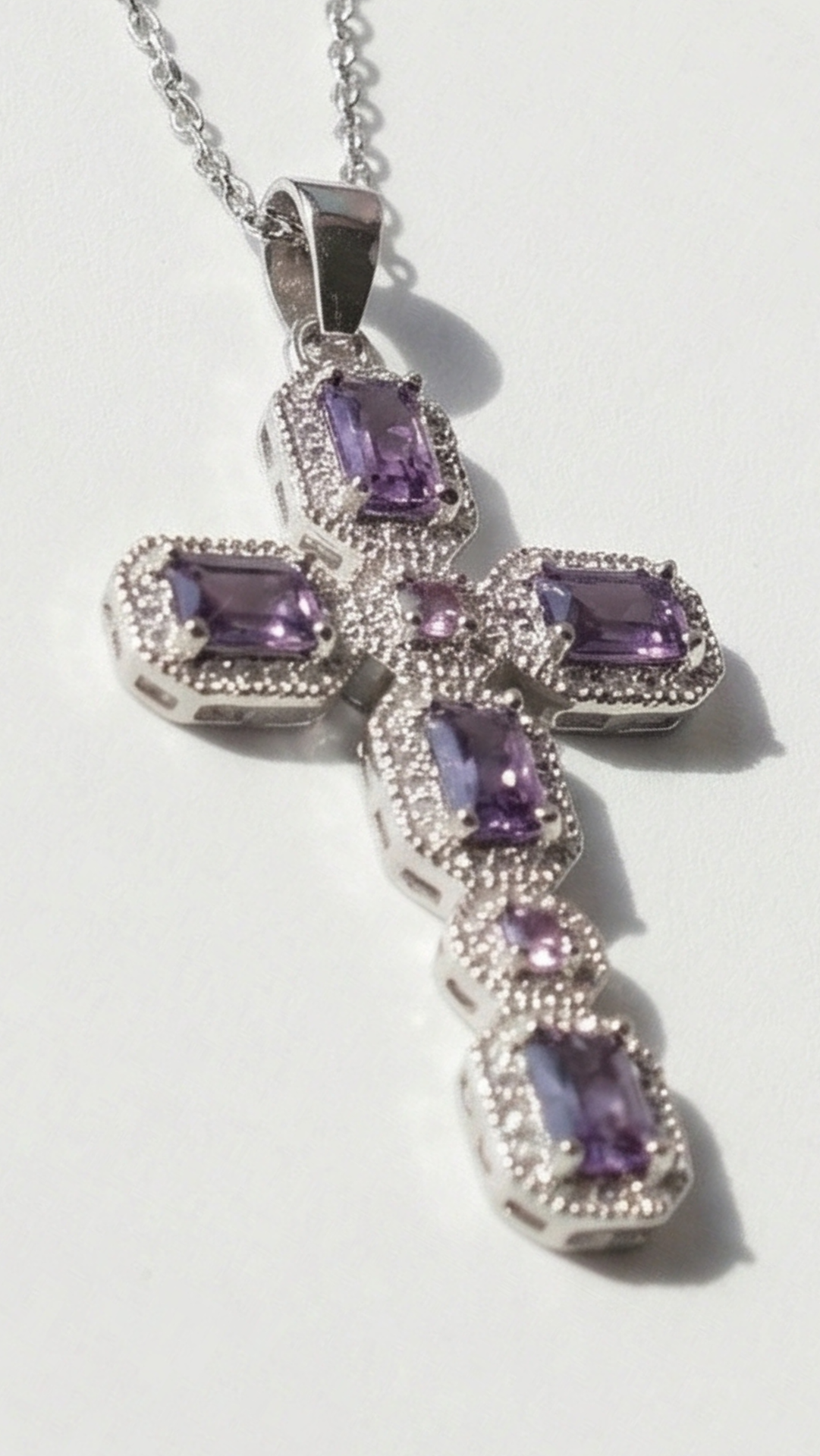 Silver necklace with purple gemstone pendant on a white background