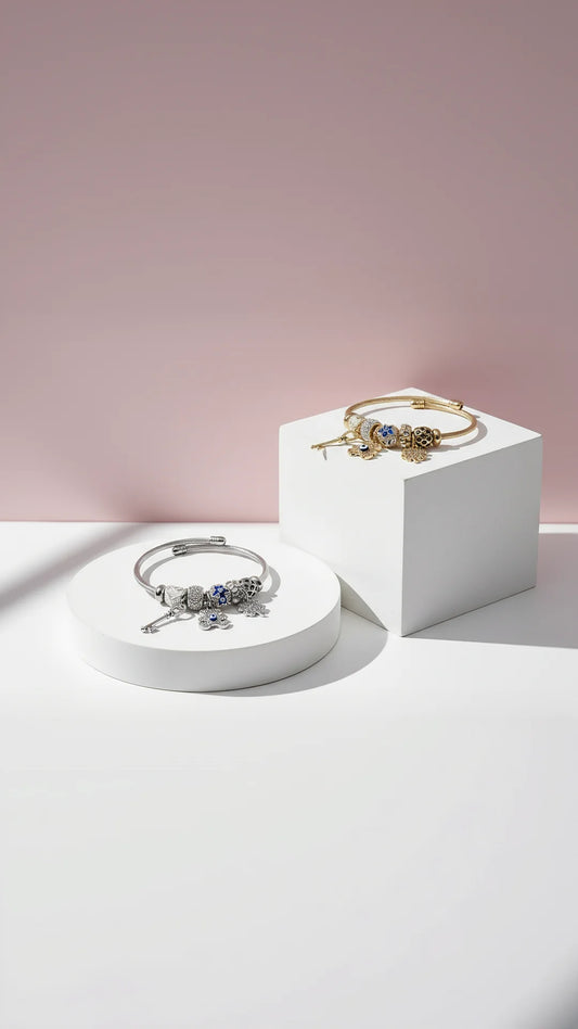 Two bracelets on white stands against a pink background