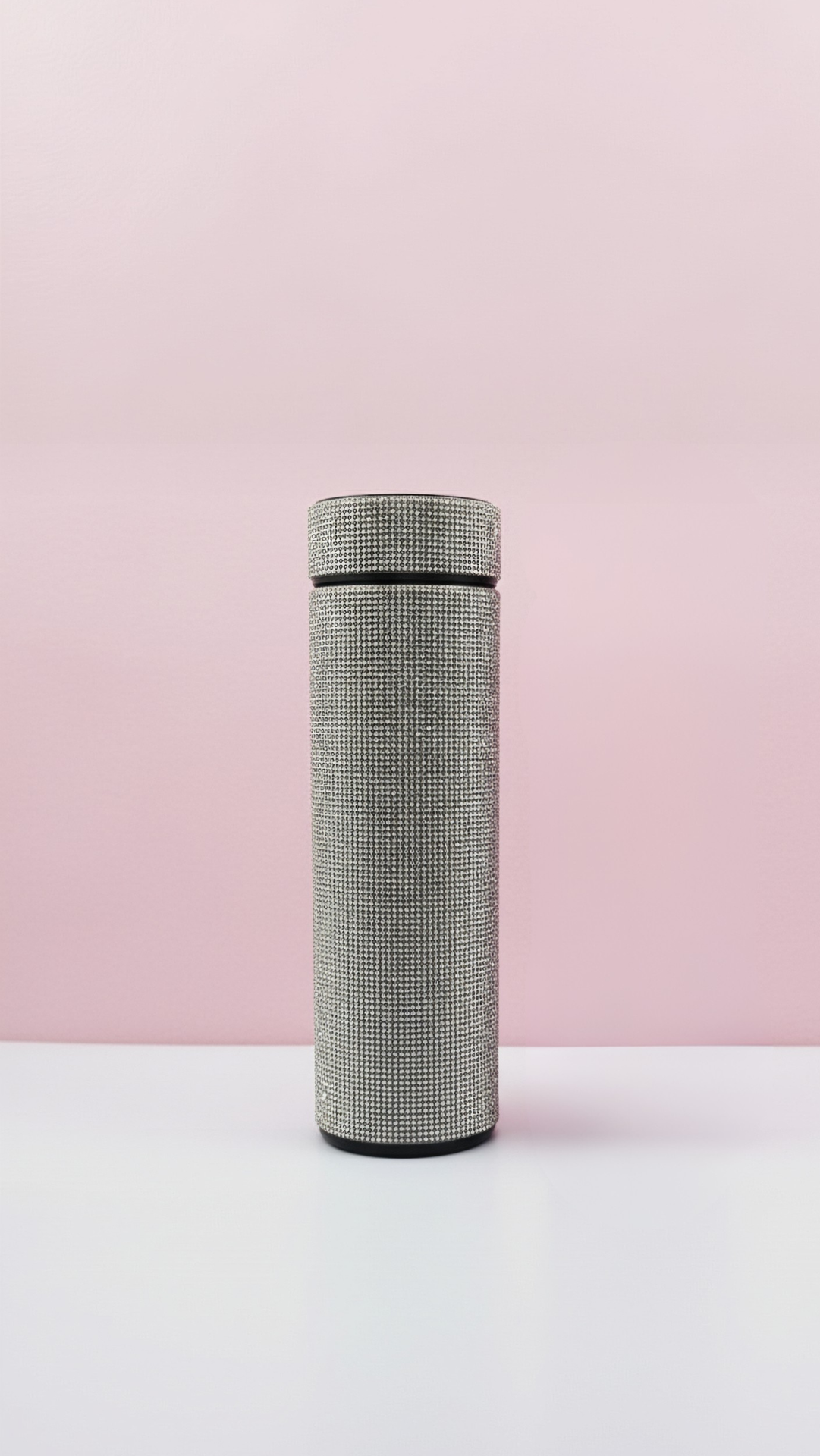 Textured cylindrical bottler on a light pink background