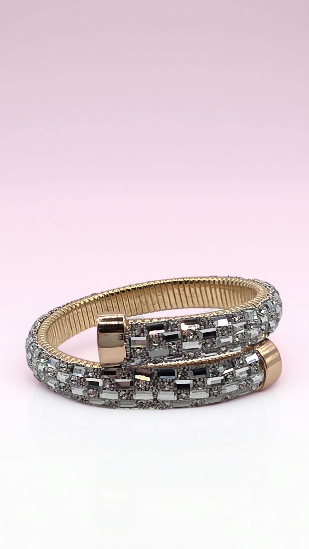Gold and silver bracelet on a light pink background