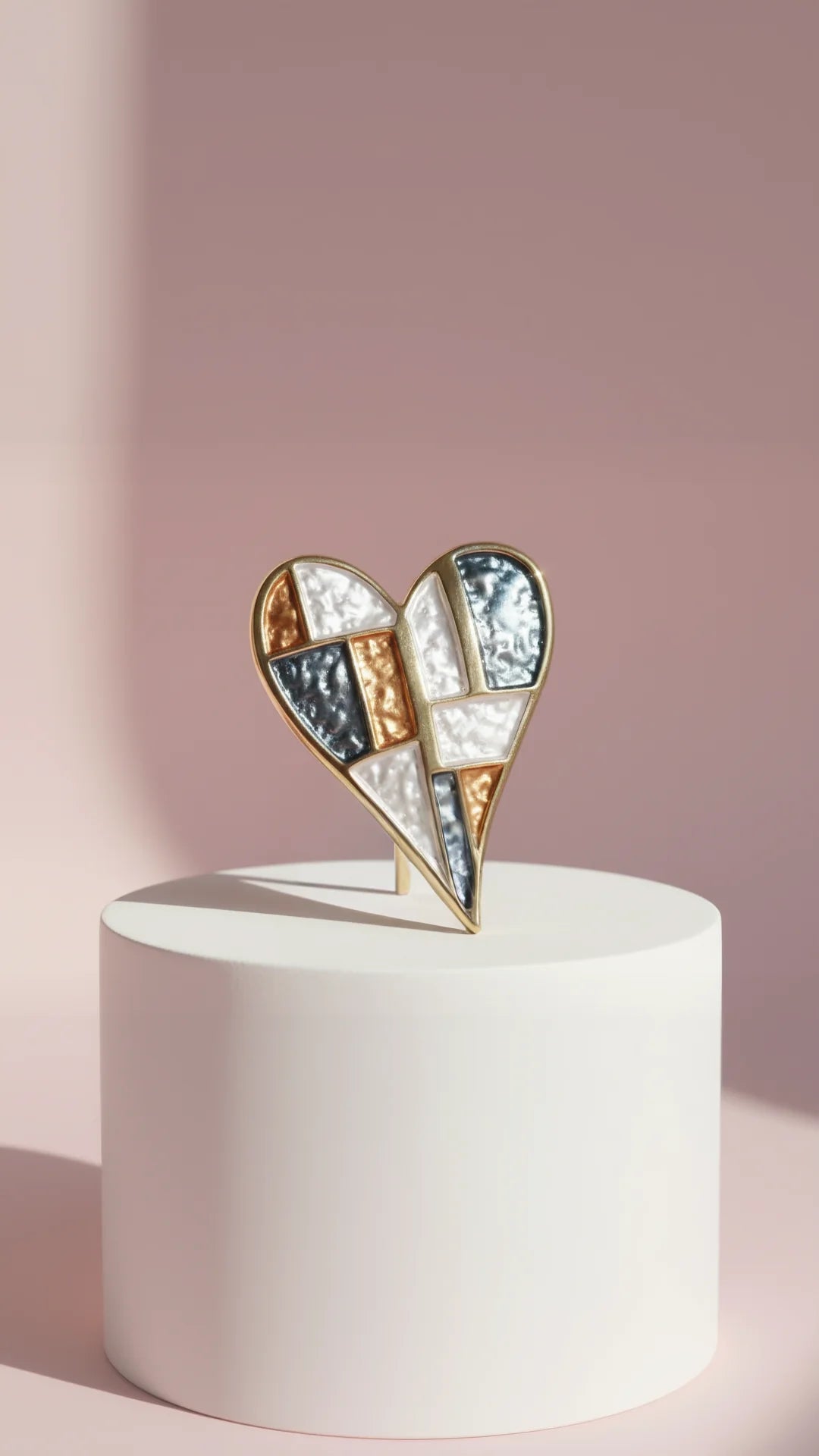Heart-shaped brooch on a white pedestal against a pink background