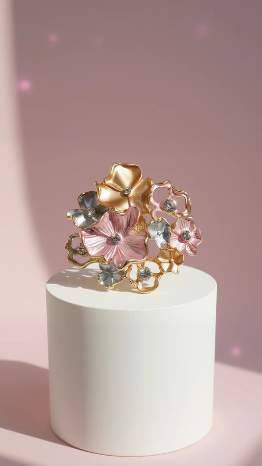 decorative floral brooch displayed on a white display, against a pink background